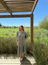 Vestido verde oliva de lino, corte suelto, con mangas abullonadas y volado en el ruedo.