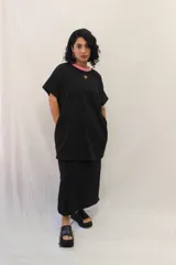 Remerón tipo vestido de corte holgado y manga corta, con cuello redondo en contraste y bolsillos laterales. Presenta un pequeño aplique decorativo en el pecho.