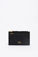 Billetera de estructura blanda confeccionada en nylon negro, con cierre de cremallera superior y bolsillo frontal con cierre. Presenta logo metálico dorado en el frente.