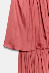 Vestido corto de cuello redondo con diseño de capa superpuesta y mangas asimétricas. Presenta cintura elástica y cierre posterior con botón.