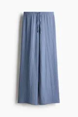 Pantalón de pierna recta y tiro medio confeccionado en punto con textura, color celeste. Cuenta con cintura elástica y cordón ajustable.