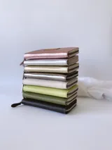 Billetera grande de cuero color negro, con cierre metálico y monedero interno.