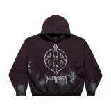 Hoodie Balenciaga de corte oversize en color negro con efecto lavado. Presenta un estampado gráfico estilo metal en el frente con el logo BB y la inscripción Balenciaga, además de detalles de salpicaduras de pintura blanca.