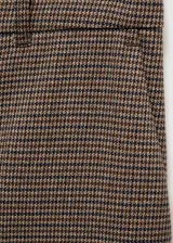 Pantalón de vestir de corte recto y tiro medio, confeccionado en tejido fluido con estampado de microcuadros en tonos marrones. Presenta trabillas en la cintura, bolsillos laterales y cierre oculto de botón, gancho y cremallera.
