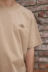 Remera de algodón color verde claro con cuello redondo y un pequeño bordado en el pecho.
