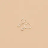 Aros de plata 925 con circonias engarzadas, de tipo argolla con dije colgante en forma de lágrima con circonia. Diámetro del aro: 12mm. Diámetro del dije: 5mm.