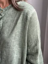 Camisa de lino verde melange, con cuello mao, mangas 3/4 y cierre frontal de botones.