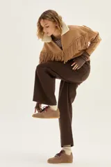 Zapatilla de cuero marrón con paneles de gamuza y cuero liso, suela de goma color caramelo y cordones bicolores en rosa y blanco.