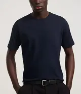 Remera básica de corte slim, confeccionada en algodón de punto medio, con cuello redondo y manga corta. Diseño liso sin estampados, ideal para un estilo versátil y cómodo.