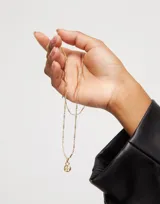 Dije dorado con forma del símbolo de la paz, bañado en oro de 18k.