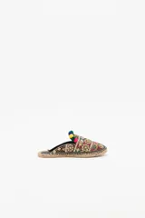 Zueco de punta cerrada con diseño multicolor, decorado con bordados étnicos, lentejuelas, canutillos y pompones de colores. Presenta una suela de yute tipo alpargata con un pequeño taco de madera de 1,5 cm y forro de cuero caprino.