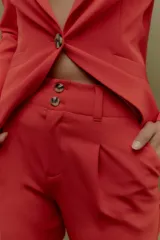 Pantalón de vestir rojo, de corte recto y tiro alto, con cierre frontal con doble botón.
