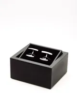 Par de gemelos plateados con centro circular negro.