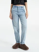 Pantalón de jean negro de corte recto, tiro alto y ruedo doblado.