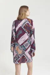 Vestido corto con estampado geométrico multicolor, escote en V con lazo y mangas largas acampanadas.