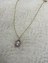 Collar con cadena dorada y dije de piedra natural pulida con cruz dorada incrustada. Disponible en tres colores: rosa, lila y blanco.