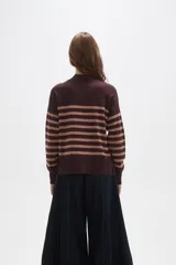 Polera de punto con diseño a rayas horizontales en contraste, cuello alto y mangas largas con puños ajustados.