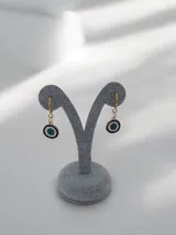 Aros tipo argolla con dije colgante en forma de ojo turco esmaltado en tonos azul, blanco y negro.