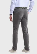Pantalón de pana gris con corte slim fit, bolsillos laterales y traseros, y cinturón trenzado verde.