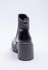 Bota de caña baja color negro, con elástico lateral, punta redonda y taco plataforma.