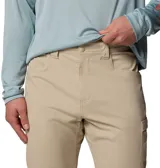 Pantalon de hombre color beige, disenado para actividades al aire libre y pesca. Cuenta con multiples bolsillos funcionales, incluyendo un bolsillo reforzado para herramientas y trabillas multiusos. Presenta tecnologia de repelencia a manchas y proteccion solar.
