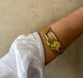 Brazalete rígido dorado con piezas irregulares.