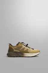 Zapatilla deportiva de trail running color beige con detalles en marrón. Presenta una parte superior de tejido técnico transpirable, refuerzos en puntera y talón, sistema de ajuste rápido con cordones técnicos y entresuela con tecnología de amortiguación y acabado moteado.