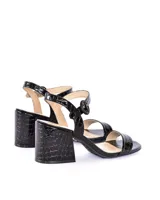Sandalias de tacón alto en color negro con textura efecto cocodrilo, diseño de tira en la puntera, talón cerrado y tira ajustable al tobillo con hebilla redonda.