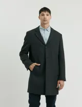 Sobretodo 3/4 de paño, color gris oscuro, con cuello solapa, cierre frontal de botones, manga larga y bolsillos laterales de ribete.