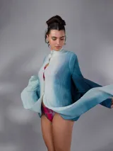 Saco largo de lana merino tejido con diseño jacquard de ramas, de líneas rectas y aberturas laterales, con efecto degradado en tonos azules y blancos, mangas largas con puños entallados y cierre frontal con pequeños botones.