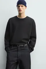 Camiseta de manga larga con corte relajado y cuello redondo. Presenta un diseño de doble capa con acabados en rib a contraste en el cuello y el ruedo.