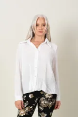 Camisa blanca plisada de manga larga con cuello clásico.