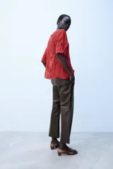 Pantalón de tiro medio confeccionado en 100% piel de color marrón, con diseño flare y costuras decorativas.