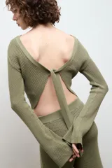 Blusa color crema de punto 100% algodón, con cuello redondo y mangas largas acampanadas.