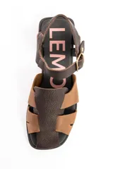 Sandalias cangrejeras de cuero tipo flats, con diseño bicolor en tonos marrón y tostado, tiras entrelazadas en el empeine y tira ajustable con hebilla en el talón.