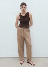 Pantalón recto color beige de lino, con cintura elástica y cordón ajustable, tiro medio y bolsillos laterales.