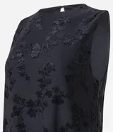 Vestido midi sin mangas, confeccionado en tejido jersey con textura floral flocada. Presenta cuello redondo y detalle de encaje en la espalda.