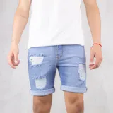 Bermuda de jean celeste con roturas y dobladillo en la botamanga.