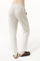 Pantalón babucha color beige de lino y viscosa, con elástico en la cintura y bolsillos laterales.