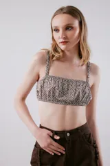 Top tipo bandeau estampado en tonos verde y blanco. Terminaciones y breteles con elástico.