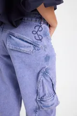 Jean de corte baggy con pierna recta y ancha, color verde oscuro con efecto lavado. Presenta bolsillos cargo laterales, costuras reforzadas y detalle de bordado del isologo en la parte trasera.