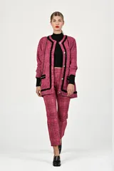 Conjunto de dos piezas compuesto por un saco tipo blazer de corte recto con cierre frontal de botones y ribetes negros en contraste, y un pantalón de vestir de corte recto a juego. Ambas prendas presentan un diseño de tejido texturizado en tonos rosa.