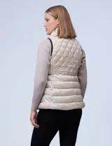 Chaleco capitoneado color rosa claro, con cuello alto, cierre frontal y bolsillos laterales.