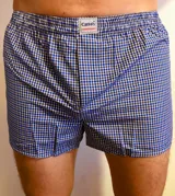 Boxer de tela con cintura elástica y estampado a cuadros azules, blancos y negros.