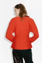 Remera de punto fino en color rojo con escote en V, cintura entallada y mangas dolman largas.