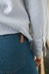Pantalon de jean azul oscuro con corte wide leg, tiro medio y costuras frontales verticales. Presenta cierre frontal con botón a la vista.