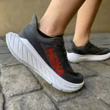 Championes Hoka Carbon X2 de hombre, color gris oscuro con detalles en rojo y suela blanca. Diseñados para running de resistencia, con placa de fibra de carbono y Meta-Rocker agresivo.