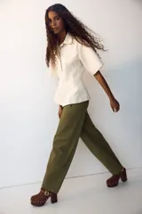Pantalón de sarga de algodón verde militar, de tiro alto con piernas estilo barrel y costuras frontales destacadas. Cuenta con cierre de cremallera y botón oculto, bolsillos discretos en las costuras laterales y bolsillos traseros insertados.