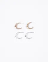 Par de aros de metal con forma de media luna y pequeñas estrellas. Un par es color dorado y el otro plateado.