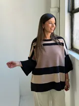 Poncho de tejido de punto con diseño de rayas horizontales anchas en color negro y beige, de corte holgado y mangas anchas.